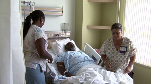 两名护理人员帮助病人起床
