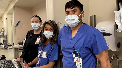 三名戴着口罩的医疗保健工作者看着相机