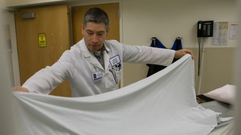 医护人员把一张白床单铺在病床上